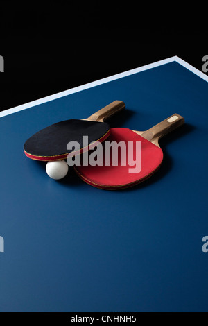 Table tennis bats and a ball on a table Stock Photo