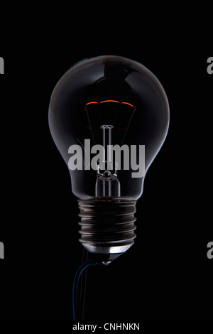 An unlit light bulb in the dark Stock Photo