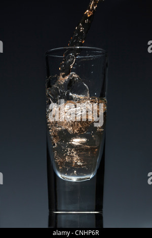 A drink being poured into a glass Stock Photo