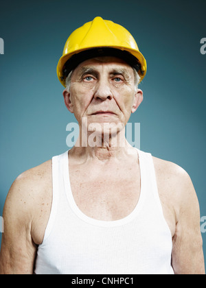 A serious senior man wearing a hardhat and tank top Stock Photo