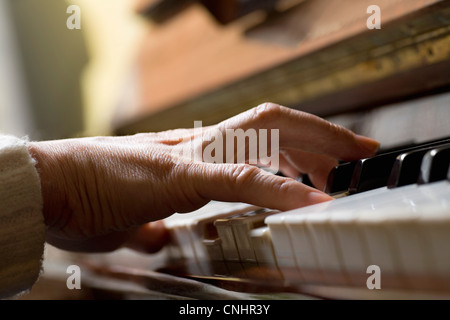 Piano chord pressed by woman's hand Stock Photo