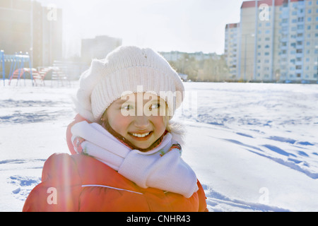 Smiling girl in winter clothes in snowy city park Stock Photo