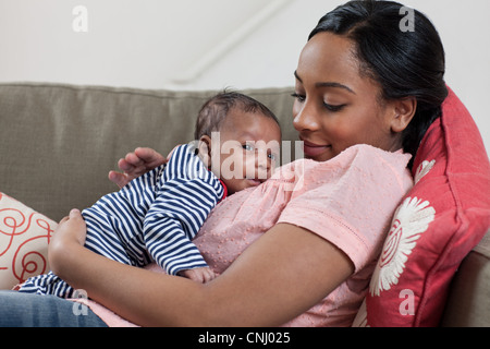 Black Mother Waking Up Her Baby Toddler After Sleep Indoor Stock Photo ...