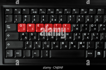 Computer laptop keyboard showing qwerty letters colored in red Stock Photo