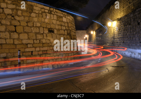 Light trails from vehicles passing through narrow corridors in the Old City of Jerusalem, Israel. Stock Photo