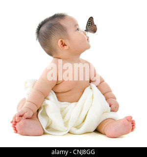 Butterfly flying to Asian baby boy nose, on white background Stock Photo