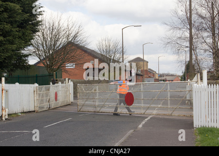 Signalman opens the manually operated level crossing gates at Daisyfield, Blackburn on the Blackburn to Clitheroe railway line. Stock Photo