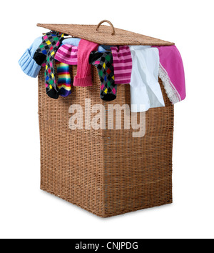 an overflowing wicker laundry basket isolated on white with clipping path showing a bust hectic lifestyle Stock Photo