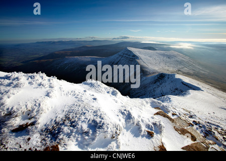 Cribyn mountain as seen from a snowy Pen Y fan summit, shortly after sunrise. Stock Photo
