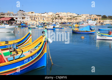 Colourful traditional wooden fishing boats within Marsaxlokk harbour, Malta, Europe Stock Photo