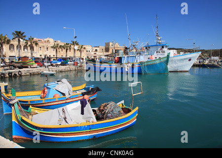 Colourful traditional wooden fishing boats within Marsaxlokk harbour, Malta, Europe Stock Photo