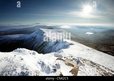 Cribyn mountain as seen from a snowy Pen Y fan summit, shortly after sunrise. Stock Photo