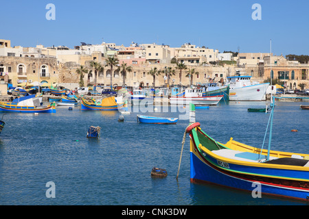 Colourful traditional wooden fishing boats within Marsaxlokk harbour, Malta, Europe Stock Photo