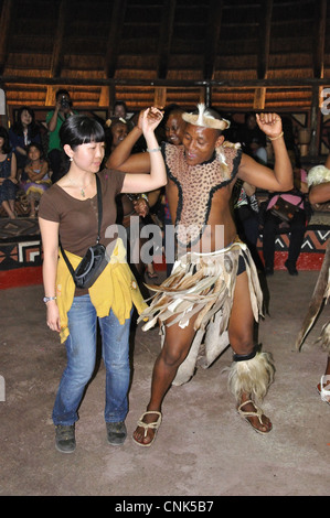 Zulu dancer with tourist at Lesedi African Cultural village, Broederstroom, Johannesburg, Gauteng, Republic of South Africa Stock Photo