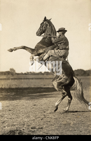 Rider Hanging Onto a Bucking Bronco Stock Photo
