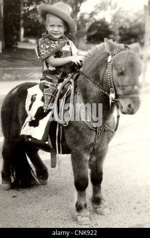 Happy Little Cowboy Riding a Pony Stock Photo