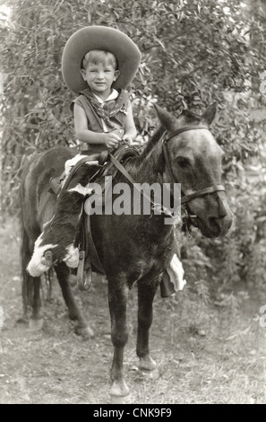 Squinting Little Cowboy Riding a Pony Stock Photo