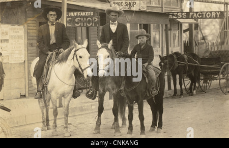 Two Men & Boy on Horseback in Western Town Stock Photo