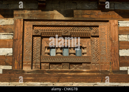 Wood carved window in a Kullu valley traditional wood and stone ethnic house in Indian Himalaya Stock Photo