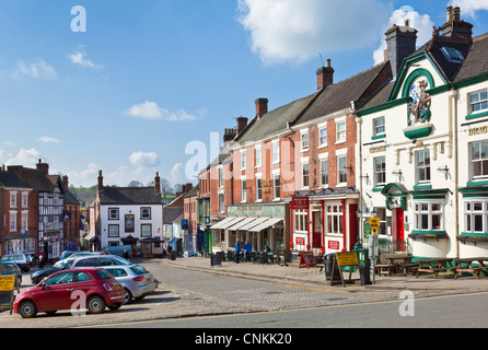 Town centre shops and parked cars in the Market Place Ashbourne Derbyshire England UK GB EU Europe Stock Photo