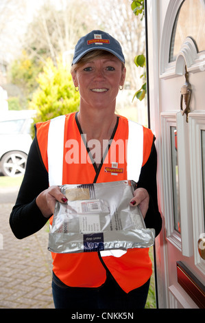 Royal Mail female post woman delivering a special delivery packet Stock Photo