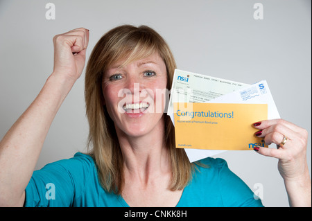 UK Premium Bond winner holding cheque from NS&I Stock Photo