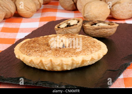 Walnut mini tart close-up on a slate tray Stock Photo