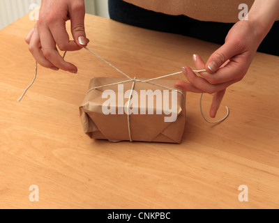 Tying Knot In String Around A Parcel Stock Photo