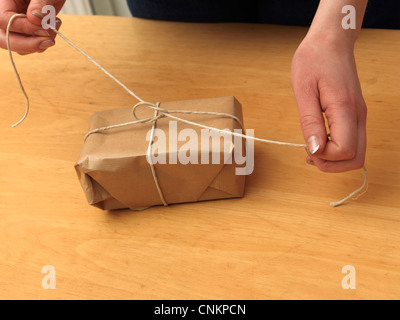 Tying Knot In String Around A Parcel Stock Photo