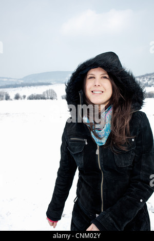 Woman in parka walking in snow Stock Photo