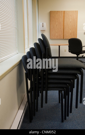Stacked chairs in an empty boardroom Stock Photo