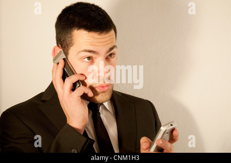 Young man using two mobile phones. Stock Photo