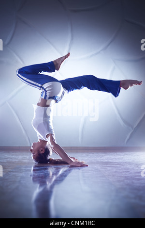 Young woman gymnast. On wall background. Stock Photo