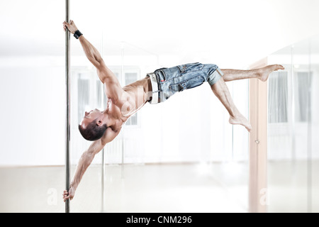 Young strong pole dance man. Stock Photo