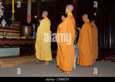 Buddhist monks praying inside the temple, Thien Mu Pagoda, Hue, Vietnam Stock Photo