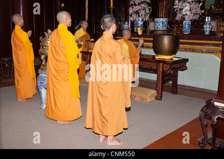 Buddhist monks praying inside the temple, Thien Mu Pagoda, Hue, Vietnam Stock Photo