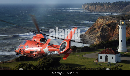 US Coast Guard Dolphin helicopter crew assigned conducts a flyover of the Point Vicente Lighthouse as part of the memorial service for fallen comrades March 18, 2012, in Los Angeles, CA. Stock Photo