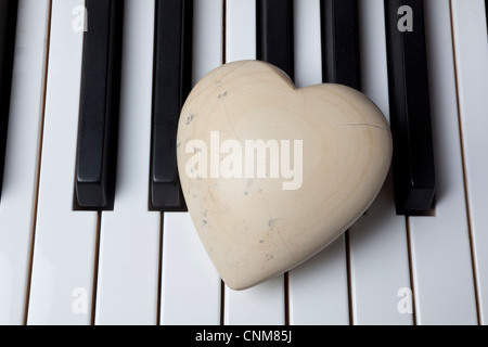 White stone heart on piano keys Stock Photo