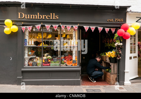 Man buying produce in an old fashioned Greengrocers shop with UK flags and balloons in a street in Canterbury, Kent, UK Stock Photo