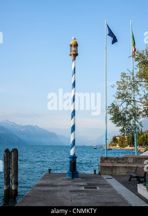 Striped beacon lamp at Torri del Benaco, Lake Garda, Italy Stock Photo