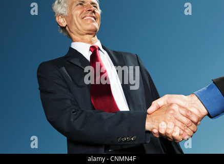Businessmen shaking hands outdoors Stock Photo
