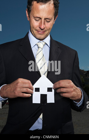 Businessman holding paper house Stock Photo