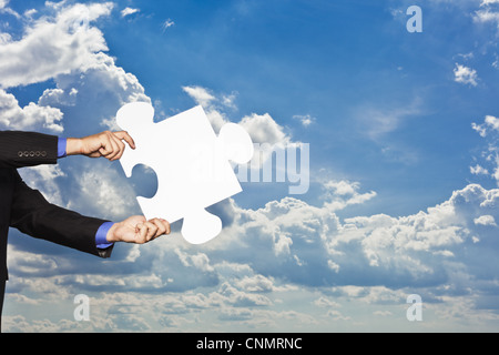 Businessman holding puzzle piece Stock Photo