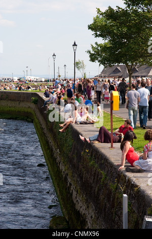 Crowds enjoying the sun at the Spanish Arch quays in Galway City ...