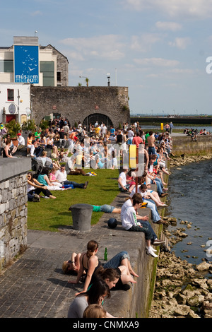 Crowds enjoying the sun at the Spanish Arch quays in Galway City ...