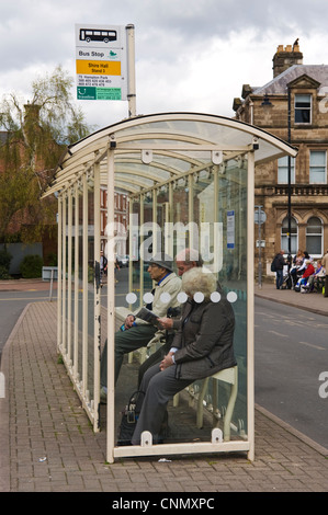 Elderly people waiting in bus shelter in city centre of Hereford Herefordshire England UK Stock Photo