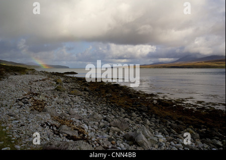 View of rainclouds and rainbow over coastal strait Islay Sound, Islay, Inner Hebrides, Scotland, september Stock Photo