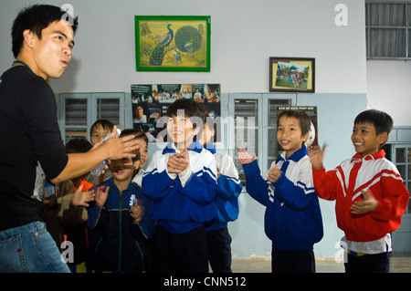 Horizontal view of Vietnamese children having fun playing and singing at an orphanage near Hue, Vietnam Stock Photo