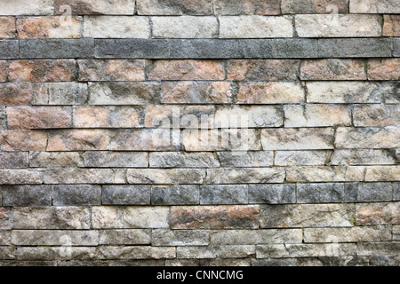 Wall texture made from rough untreated marble bricks of different sizes Stock Photo