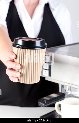 Photo of a Barista handing you a coffee in a disposable paper takeaway cup. Stock Photo